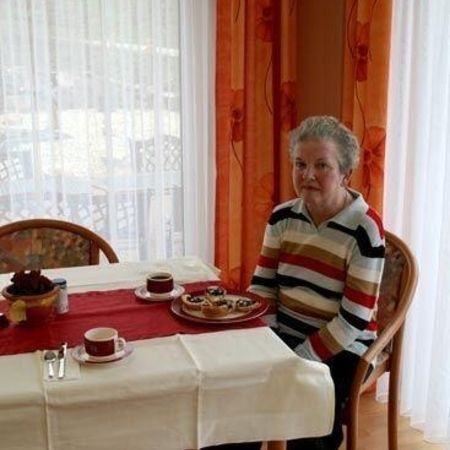 Eine alte Bewohnerin des Hauses sitzt am Esstisch