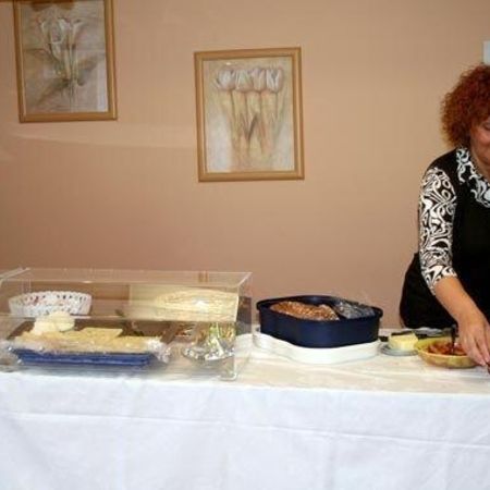 Eine Frau bereitet das Buffet auf einem großen Tisch vor