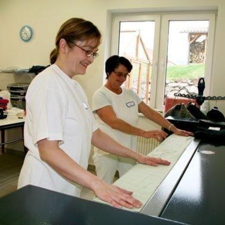 Zwei Mitarbeiterinnen der Wäscherei arbeiten